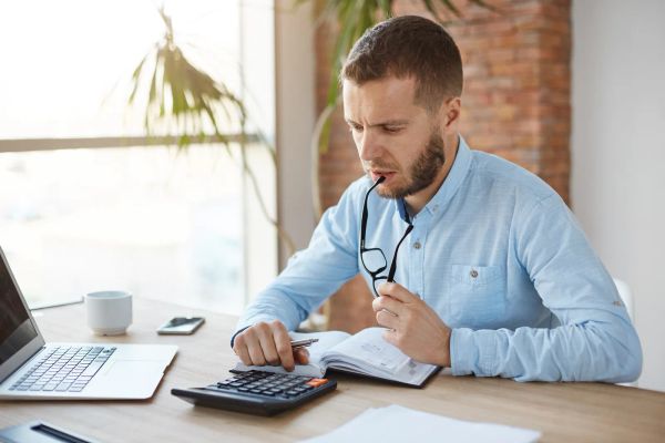 Business owner comparing costs at his desk