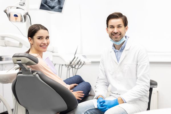 Friendly dentist with a smiling patient in a modern dental office