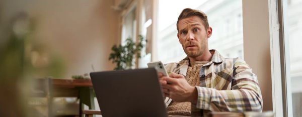 Business owner sitting with a laptop and smartphone weighing her options