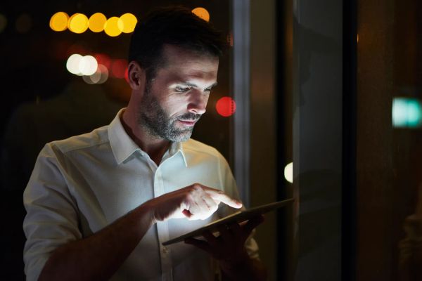 Businessman reviewing settings on a tablet in his office