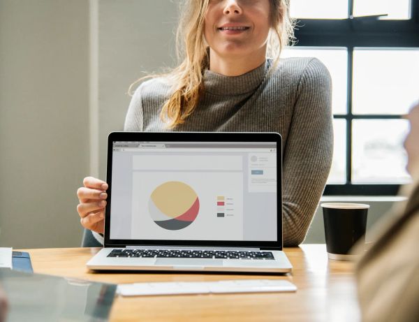 Woman pointing at a laptop screen while reviewing a website layout