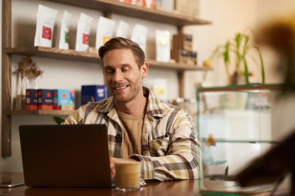 Cafe owner working on his website from the counter