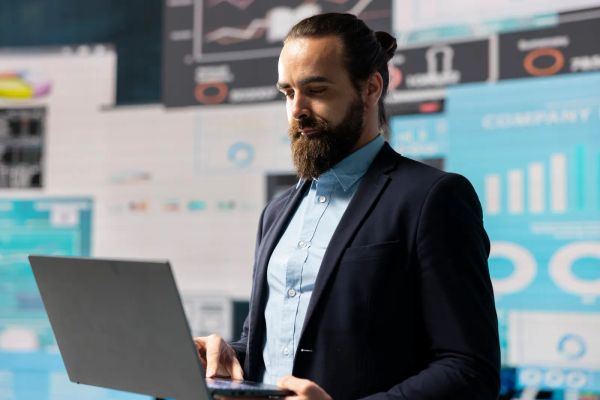Business owner comparing marketing data and charts on a laptop
