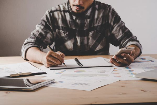 Business owner tracking SEO progress in a notebook