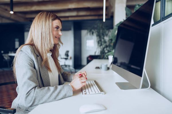 Small business owner working carefully on her laptop at her desk
