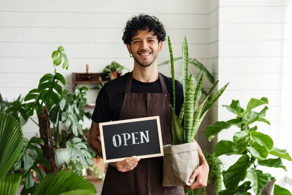 Small business owner holding a We Are Open sign