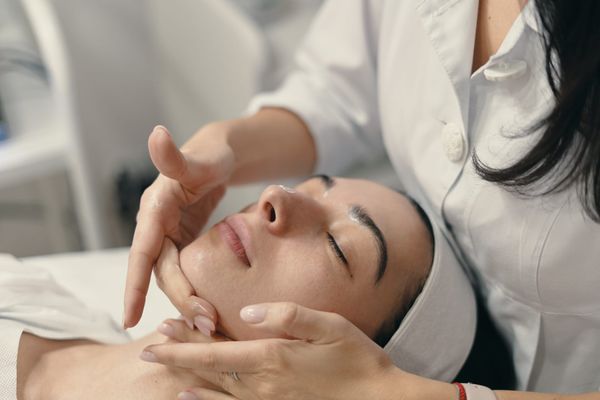 Woman relaxing during a facial skin rejuvenation treatment at a professional med spa