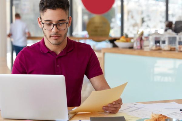 Small business owner reviewing website text on a laptop in a coffee shop