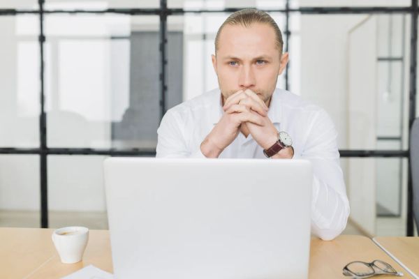 Businessman waiting in front of his laptop