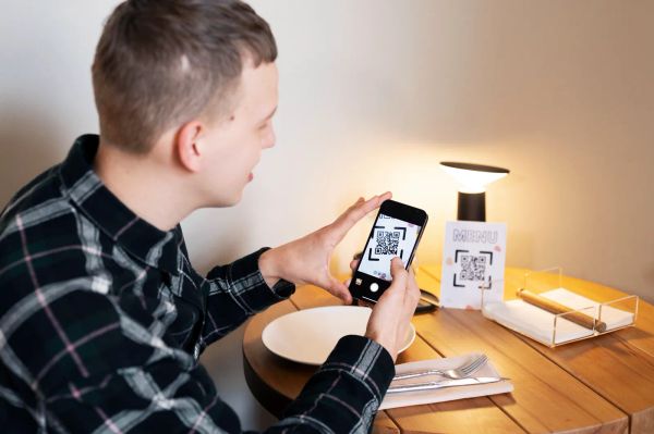 Smiling business owner scanning a QR code with his phone