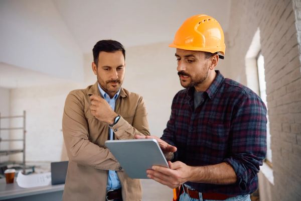 Contractor showing a tablet with his licensed and insured credentials to a homeowner
