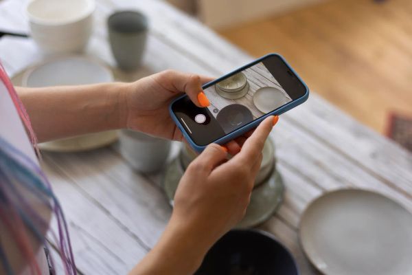 Small business owner photographing her own handmade kitchenware for her website