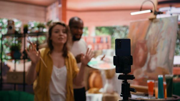 Small business owners setting up a phone on a tripod to record a video