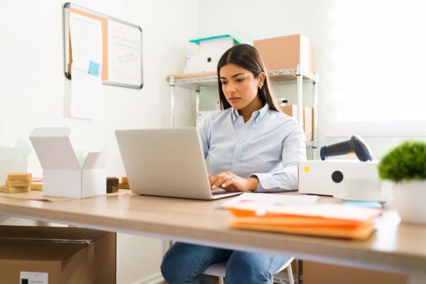 Business owner reviewing her website at her desk