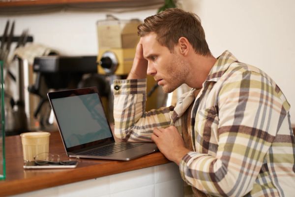 Business owner puzzled by a warning on his laptop screen